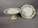 two plates and a bowl on a stand on a gray surface