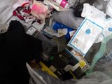 a pile of garbage in a trash can with a cell phone in it