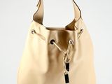 beige leather handbag hanging from a hook on a white wall