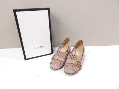 une paire de chaussures roses posée sur une table blanche