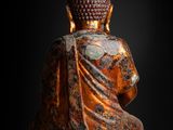 a statue of a buddha sitting on a black background