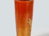 a red vase with a gold leaf design on it