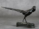 une statue représentant un oiseau posé sur un socle