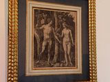 a framed picture of two nudes hanging on a wall