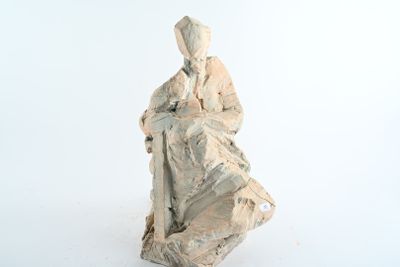 une statue représentant une femme assise sur un rocher
