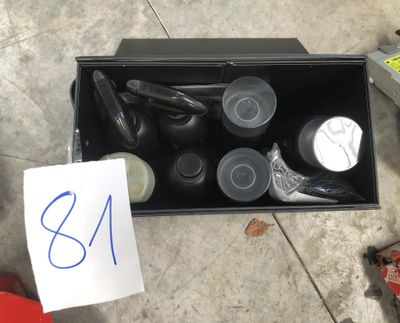 une boîte posée par terre, contenant tout un tas de chaussures