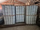 Plusieurs piles de palettes sont empilées les unes sur les autres dans un entrepôt