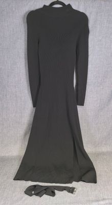 La robe est noire et présente un col.