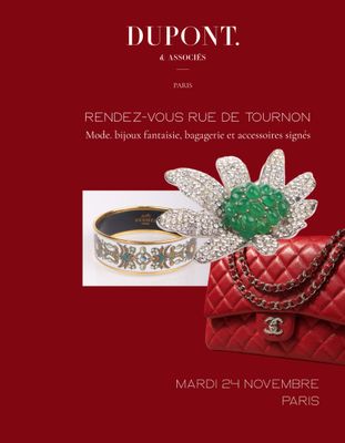 a red book with a red purse and a green flower on it
