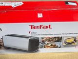 une boîte contenant un grille-pain Tefal posée sur une table