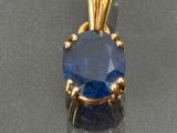 an image of a blue sapphire and diamond pendant on a silver surface