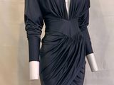 Le mannequin porte une robe noire à manches longues.