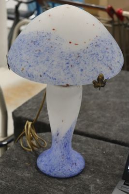 une lampe bleue et blanche posée sur une table à côté d'un ordinateur portable