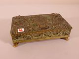 an ornate brass box with a red sticker on top of it