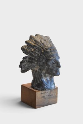 statue of a native american indian head on a wooden base