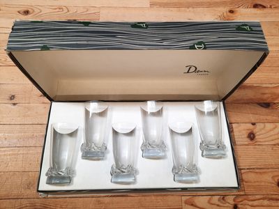 six glasses in a box on a wooden floor