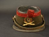 a military hat with a red ribbon on top of it