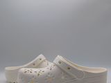 the white crocs are lined up with holes and holes on them