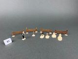 a small group of miniature figurines of people in a fenced in area