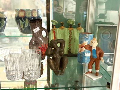 une vitrine remplie de vases et de figurines en verre