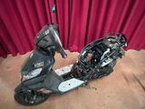 un scooter posé par terre devant un rideau rouge