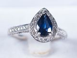 a close up view of a blue sapphire and diamond ring