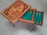 une table en bois sur laquelle se trouvent un plateau de jeu et un tiroir