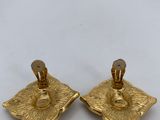 pair of gold plated candlesticks on a white table