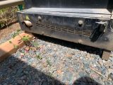 a black grill sitting on top of a pile of rocks