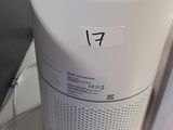 un purificateur d'air blanc posé sur un bureau, à côté d'un ordinateur portable