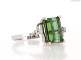 an image of a green tourmaline and diamond ring on a white surface