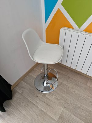 a white bar stool sitting in front of a radiator