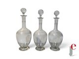 trois bouteilles en verre transparent posées les unes à côté des autres sur une surface blanche