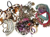 a pile of assorted bracelets on a white surface