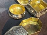 three silver and gold boxes sitting on top of a table