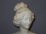 a white statue of a woman with a bun on her head