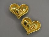 two gold heart shaped brooches with initials on them