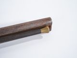 a wooden stick with a handle on a white surface