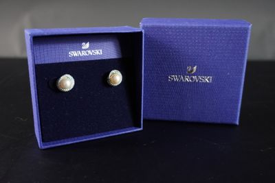 une paire de boucles d'oreilles dans une boîte bleue posée sur une table