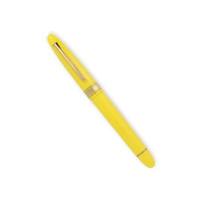 un stylo à bille jaune posé sur une surface blanche