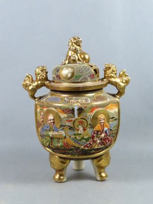 une image représentant un vase de couleur dorée surmonté d'un lion