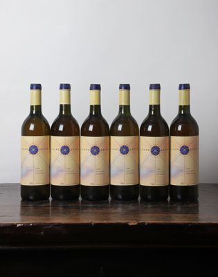 six bouteilles de vin sont alignées sur une table en bois