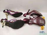 three pairs of women ' s purple shoes on a white surface