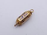 a small gold object with a blue and white design on it