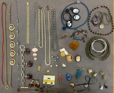 many different necklaces and bracelets laid out on a table