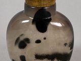 a small glass bottle with a black and white design on it