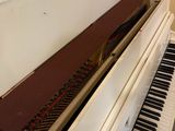 a white piano that is sitting in the corner of a room