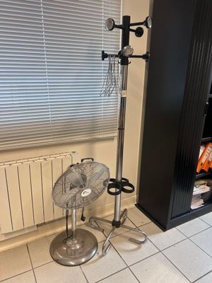 a fan sitting on the floor in front of a window