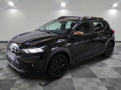 une voiture noire est garée dans une pièce au sol en damier