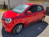une photo d'une petite voiture rouge garée devant un immeuble